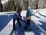 The staff assists with boarding the drag lift.