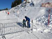 The staff assists with boarding at the drag lift.