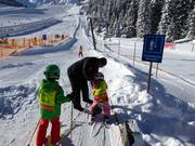 Children are assisted when getting on the platter lift.