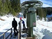 The staff assists with boarding the platter lift.