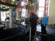 The staff assists with the skis when boarding.