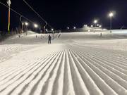 Before night skiing, the slopes are groomed again.