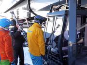 The friendly staff assists with boarding at the gondola lift.