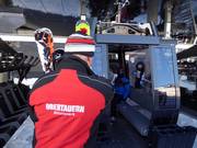 The friendly staff assists with boarding at the gondola lift.
