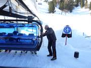 The staff assists with boarding at the chairlift.